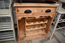 A modern pine kitchen storage unit with wine rack and under drawer