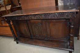 An early 20th century oak sideboard/dresser base having Gothic styled carved panel with cupboards