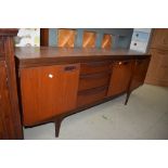 A mid century teak side board or Long John having three drawers and three section cupboard