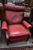 A mid century reclining arm chair or lazy boy having blood red leather