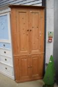 A stripped pine corner cupboard