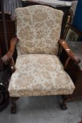 A reproduction Queen Anne style armchair having ball and claw feet