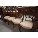 A set of four Victorian balloon back dining chairs having carved fruit and leaf backs on cabriole