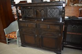 A mid to late 20th century dark oak court cupboard having leaded glazed doors with cupboard and