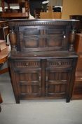 A 20th century dark oak sideboard having under and over cupboard with two drawers