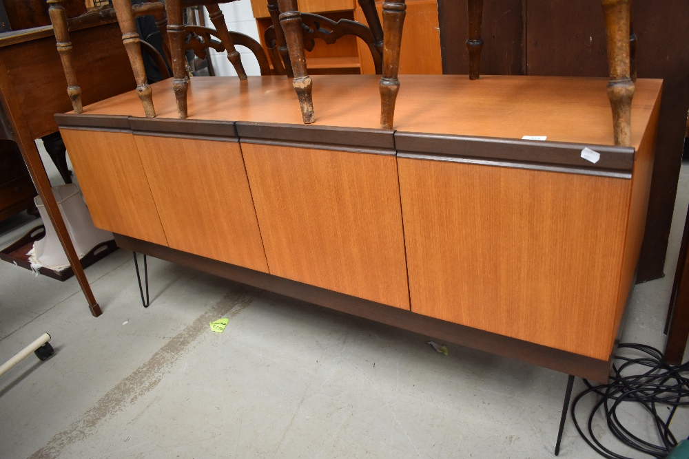 A 1960s E Gomme G Plan sideboard having four doors to two compartments and later hair pin legs.