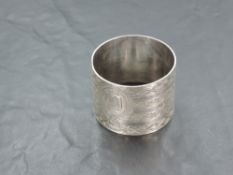 A large Edwardian silver napkin ring, of circular form with repeating geometric decoration centred