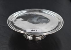 An Edwardian Britannia silver pedestal visiting card tray, of moulded circular form, raised on a