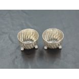 A pair of Victorian silver salts, of circular spirally fluted form with beaded rim, raised on