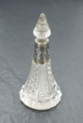 An Edwardian cut glass perfume bottle of conical form having cut glass stopper and moulded silver