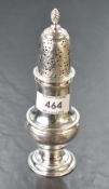 A George III silver sugar caster, of traditional form with spirally fluted finial over the domed and