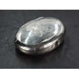 An Edwardian silver snuff box, of oval form curved for the gentleman's pocket, the hinged cover with