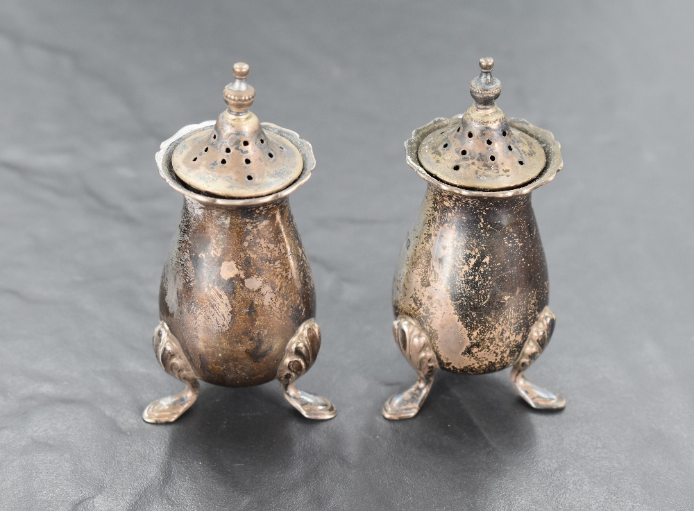 A pair of George V silver pepperettes, of baluster form with pierced finial topped pull-off