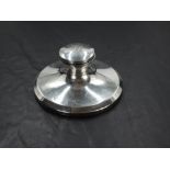 A George V silver Capstan inkwell, of flared circular form with hinged domed cover engraved with