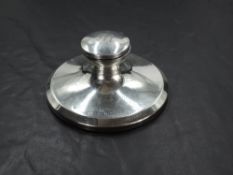 A George V silver Capstan inkwell, of flared circular form with hinged domed cover engraved with
