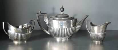 An Edwardian silver three piece teaset, of half fluted oval form with angular handles, marks for