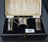A George V cased silver condiment set, comprising a salt, pepperette and mustard, each of circular
