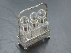A group of three George V silver mounted glass scent bottles, each with faceted stoppers, the mounts