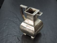 A Victorian silver cream jug, of square section baluster form with angular handle and half fluted