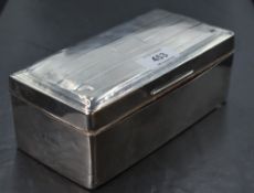 A George V silver table cigarette box, of hinged oblong form with bands of engine-turned