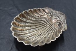 An Edwardian silver butter dish, of scallop shell form with three ball feet, marks for London