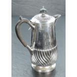 A George VI silver hot water pot, having a domed and fluted hinged cover with ebony finial over