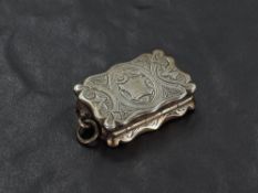 A Victorian silver vinaigrette, of shaped and hinged rectangular form with engraved detail, the