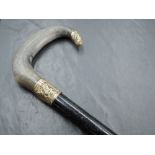An early 20th century gilt metal mounted and horn handled walking cane, the ebonised shaft with