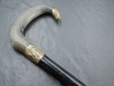 An early 20th century gilt metal mounted and horn handled walking cane, the ebonised shaft with