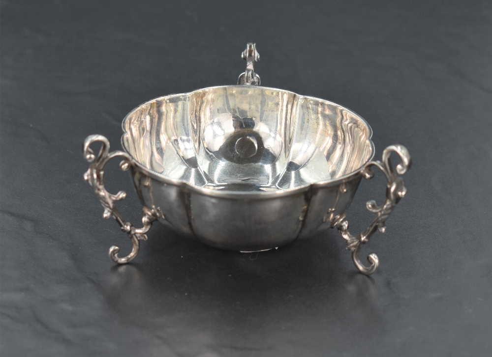 An Edwardian silver bowl, of lobed circular form with three applied scrolling handles extending as