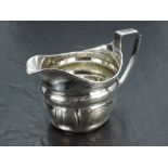 A George III silver cream jug, of helmet form with reeded rim and moulded body with bands of