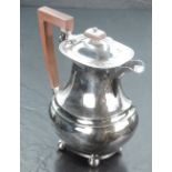 A 1930's silver hot water pot, of rounded rectangular baluster form, the hinged finial topped