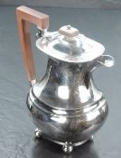 A 1930's silver hot water pot, of rounded rectangular baluster form, the hinged finial topped