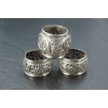 A group of three Eastern white metal napkin rings, most likely Indian, with embossed and pierced
