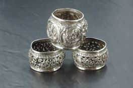 A group of three Eastern white metal napkin rings, most likely Indian, with embossed and pierced