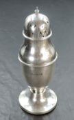 A silver sugar caster, of urn form having push on pierced lid and weighted pedestal base, Birmingham