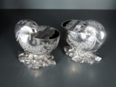 A pair of late Victorian silver plated nautilus shell form spoon warmers, with engraved foliate