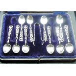 An incomplete cased set of ten silver teaspoons and sugar tongs with pierced Welsh love spoon type