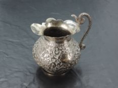 An eastern white metal cream jug, of baluster form with flared rim and generous spout, opposed by