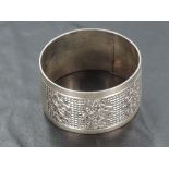 An Edwardian silver napkin ring, of circular form with geometric decoration and vacant shield-form