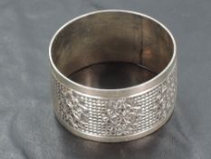 An Edwardian silver napkin ring, of circular form with geometric decoration and vacant shield-form