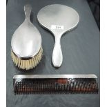 A 1960's silver three-piece dressing table set, comprising hand mirror, hair brush and comb of