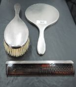 A 1960's silver three-piece dressing table set, comprising hand mirror, hair brush and comb of