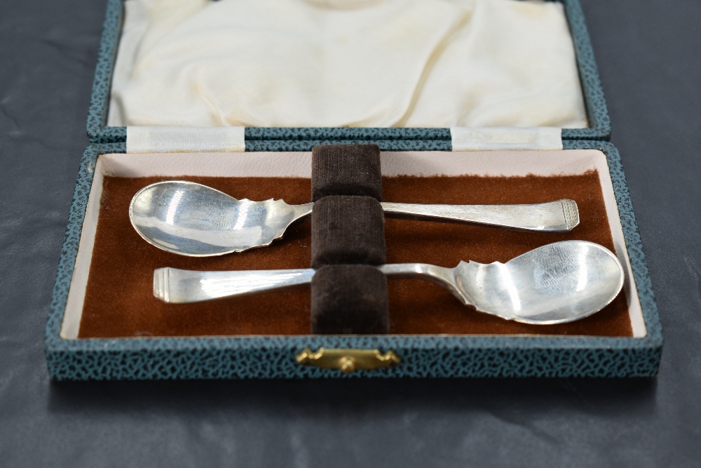 A 1940's cased set of two silver preserve spoons, of shaped but plain form with shallow bowls, marks