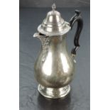 An Edward VII silver hot water pot, hading a moulded and domed finial topped cover with gadrooned