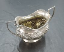 An Edwardian silver sucrier, of twin handled oval form embossed with foliate and C-scroll