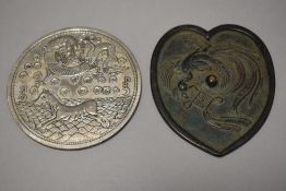 An 18th century Chinese bronze mirror having Phoenix decoration in a heart shaped design along