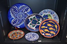 A selection of Spanish and Italian styled ceramics including large charger, fruit bowl and plaques