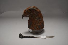 A wrought iron letter opener with rams head design and a cast metal eagle head