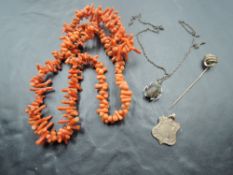 A string of branch coral, yellow metal stick pin of knot form, a 9ct rose gold shield medallion,